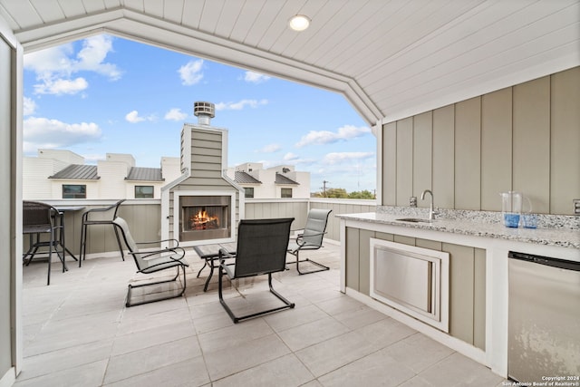 view of patio / terrace with an outdoor fireplace and sink