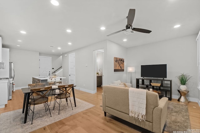 living room with ceiling fan, sink, and light hardwood / wood-style flooring