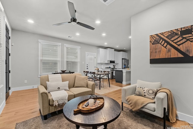 living room featuring ceiling fan and light hardwood / wood-style flooring