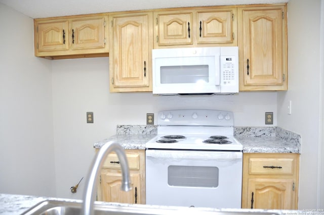 kitchen featuring light brown cabinets, white appliances, and sink