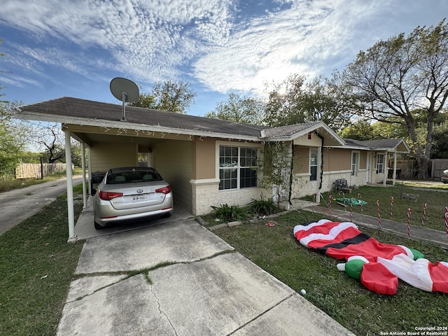 ranch-style house featuring a front lawn and a carport