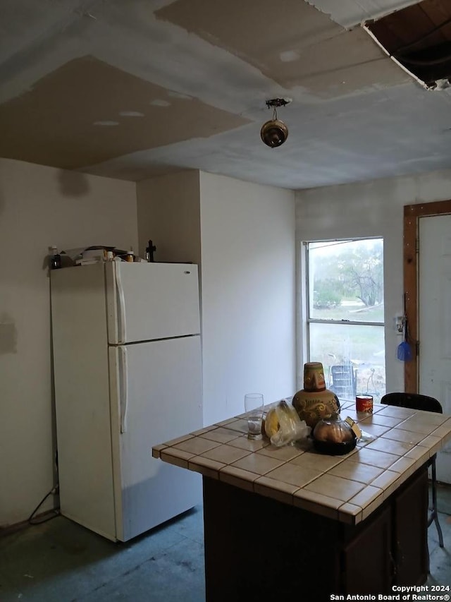 kitchen with tile counters and white fridge