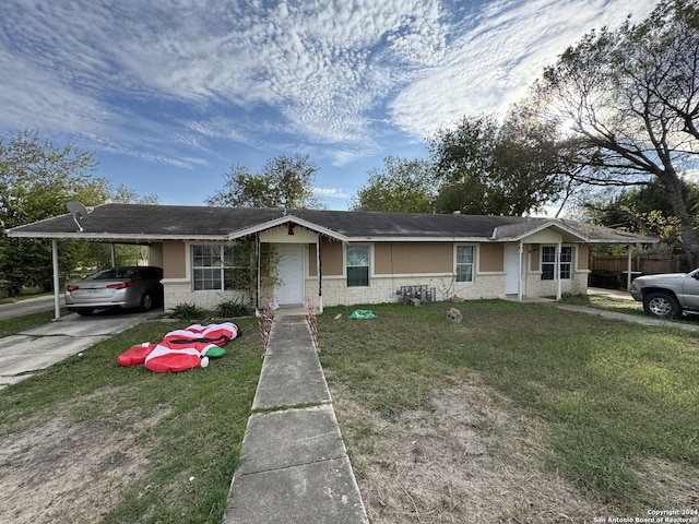 ranch-style home featuring a front lawn and a carport