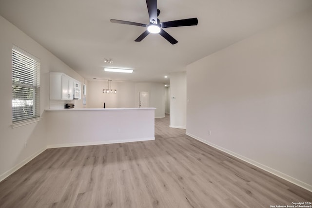 unfurnished living room featuring light wood-type flooring and ceiling fan