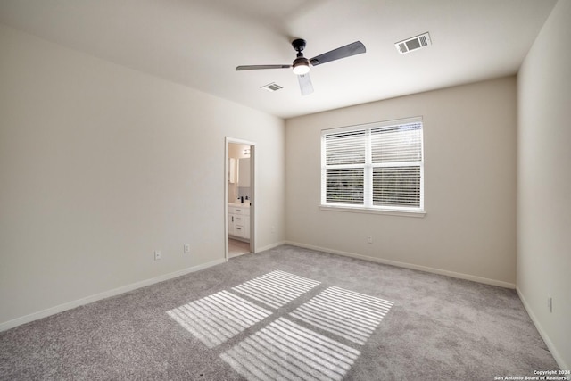 unfurnished bedroom with light carpet, connected bathroom, and ceiling fan