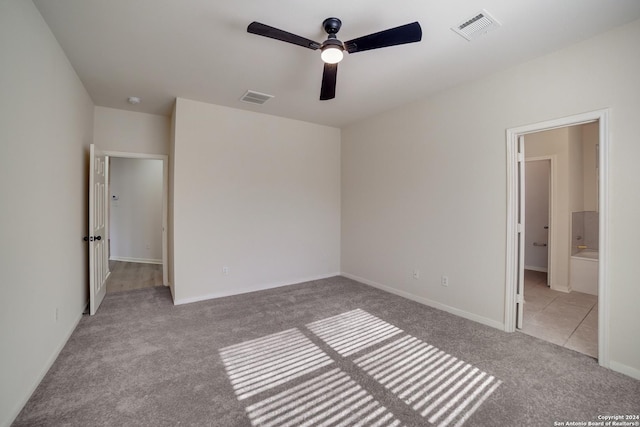 unfurnished bedroom with ensuite bathroom, ceiling fan, and light carpet