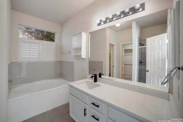 bathroom with plus walk in shower, tile patterned flooring, and vanity