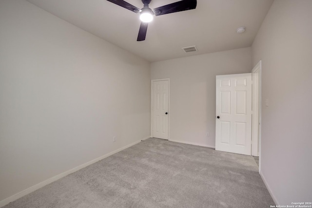 empty room featuring ceiling fan and light colored carpet