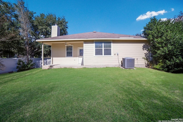 rear view of property with a lawn, central AC, and ceiling fan