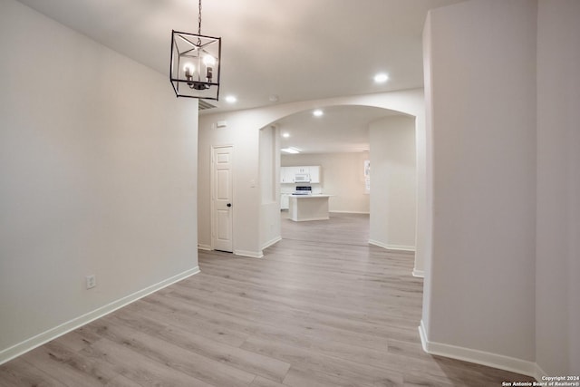 hall with a chandelier and light hardwood / wood-style floors