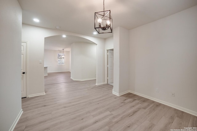 unfurnished dining area with light hardwood / wood-style floors and an inviting chandelier