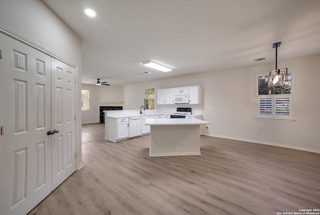 kitchen featuring kitchen peninsula, plenty of natural light, pendant lighting, and white appliances