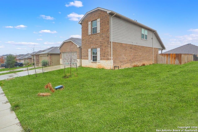 view of side of property featuring a garage and a lawn