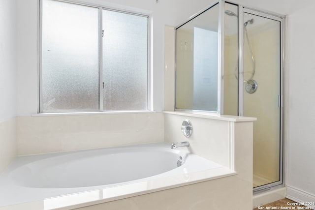 bathroom featuring shower with separate bathtub and a wealth of natural light