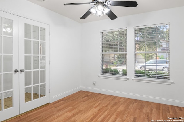 empty room with ceiling fan, light hardwood / wood-style flooring, and french doors