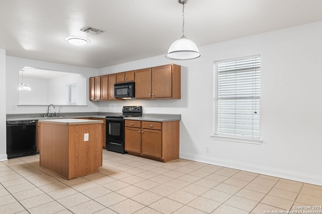 kitchen featuring sink, black appliances, pendant lighting, an inviting chandelier, and a center island