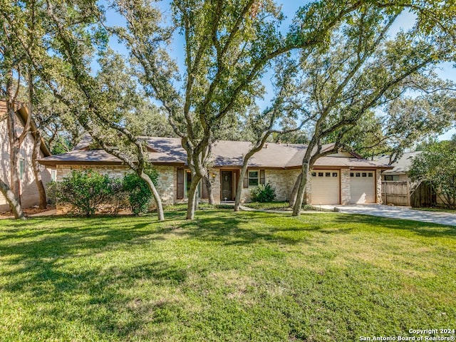 single story home featuring a front lawn and a garage