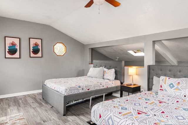 bedroom with ceiling fan, vaulted ceiling, and light wood-type flooring