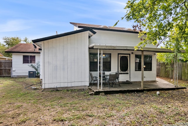 rear view of house with central AC and a deck