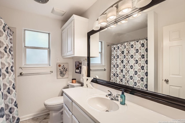 bathroom with vanity, a wealth of natural light, tile patterned floors, and toilet