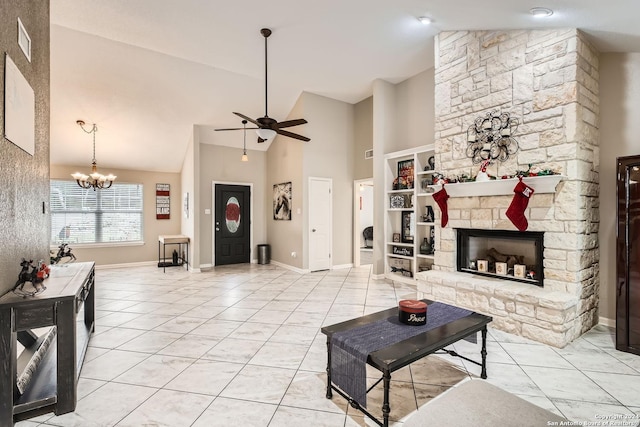 tiled living room featuring ceiling fan with notable chandelier, a fireplace, and high vaulted ceiling