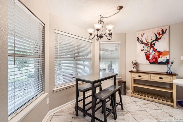 dining space featuring a wealth of natural light, a textured ceiling, and a chandelier