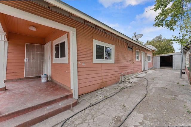 view of property exterior featuring a patio area and a shed