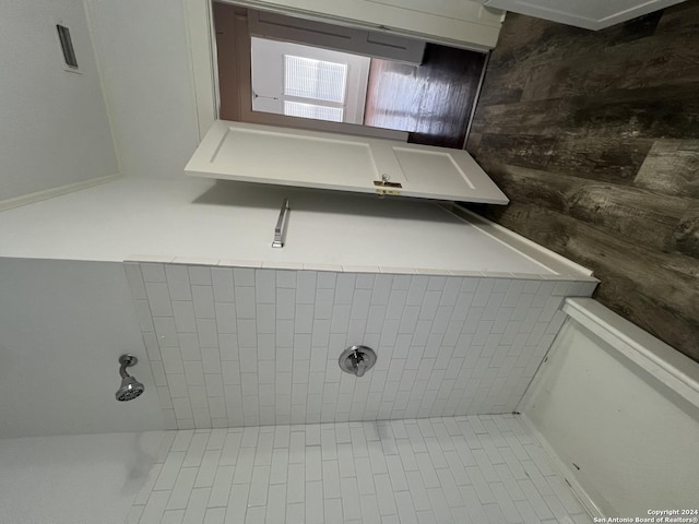 bathroom with a tile shower and tile patterned floors