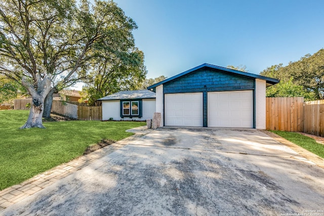 single story home featuring a garage and a front yard