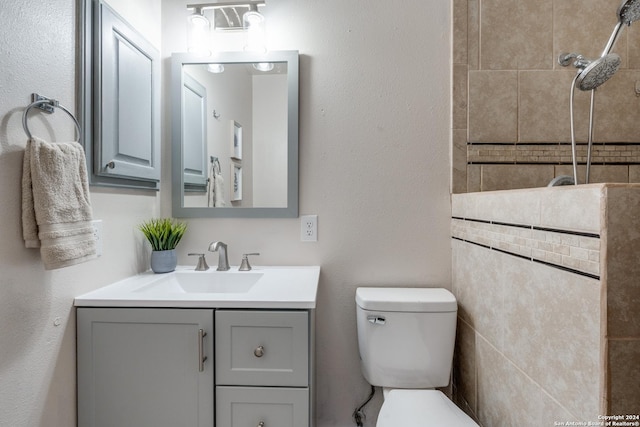 bathroom featuring vanity, toilet, and tile walls