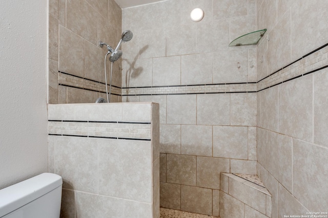 bathroom with tiled shower and toilet