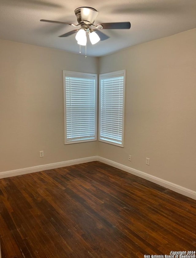 empty room with ceiling fan and dark wood-type flooring