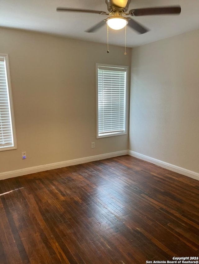 empty room featuring dark hardwood / wood-style flooring and ceiling fan