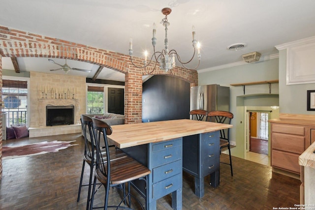 kitchen with pendant lighting, a healthy amount of sunlight, white cabinetry, and wooden counters