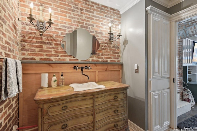 bathroom featuring vanity, brick wall, and ornamental molding