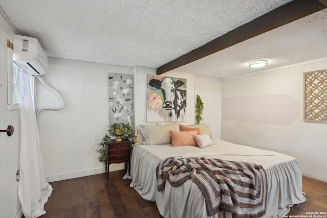 bedroom featuring beamed ceiling, dark wood-type flooring, a wall unit AC, and a textured ceiling