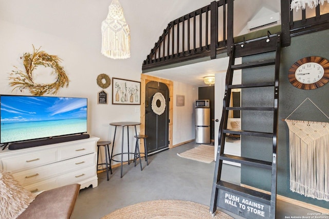 living room featuring a wall unit AC and concrete flooring