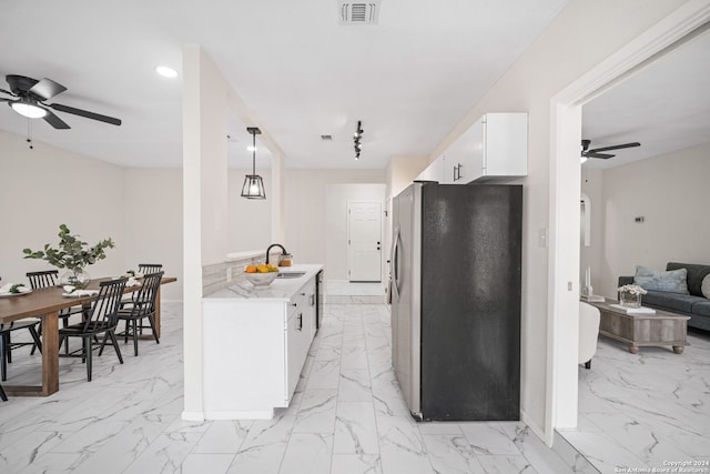 kitchen with ceiling fan, decorative light fixtures, white cabinetry, and stainless steel refrigerator