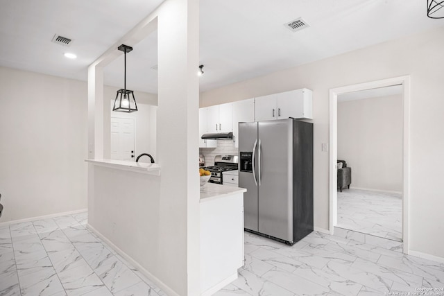 kitchen featuring decorative backsplash, appliances with stainless steel finishes, sink, white cabinetry, and hanging light fixtures