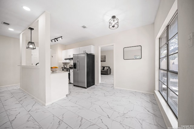 kitchen with kitchen peninsula, decorative light fixtures, decorative backsplash, white cabinets, and appliances with stainless steel finishes