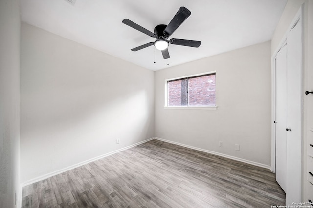 unfurnished bedroom featuring ceiling fan, wood-type flooring, and a closet