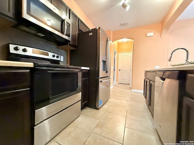 kitchen with sink, light tile patterned flooring, and stainless steel appliances