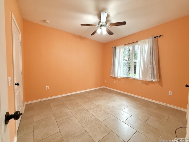 tiled spare room with ceiling fan