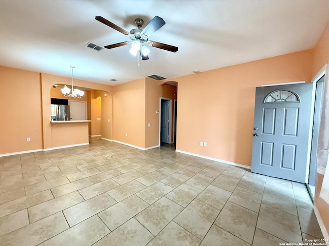 unfurnished living room featuring ceiling fan with notable chandelier