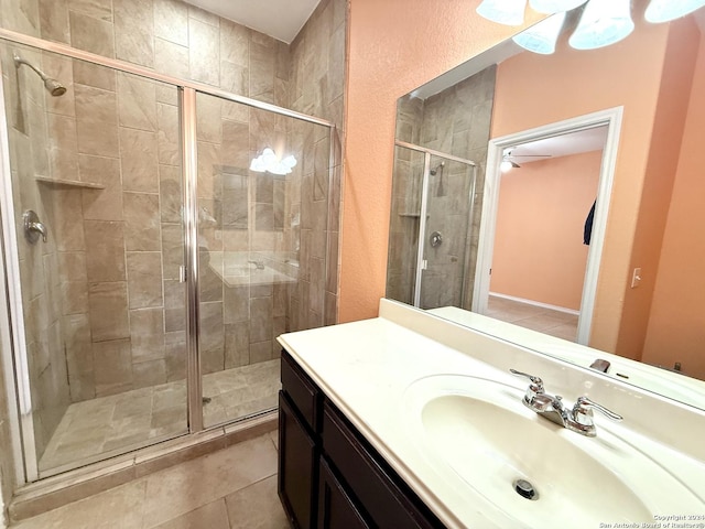 bathroom with tile patterned flooring, vanity, ceiling fan, and a shower with shower door