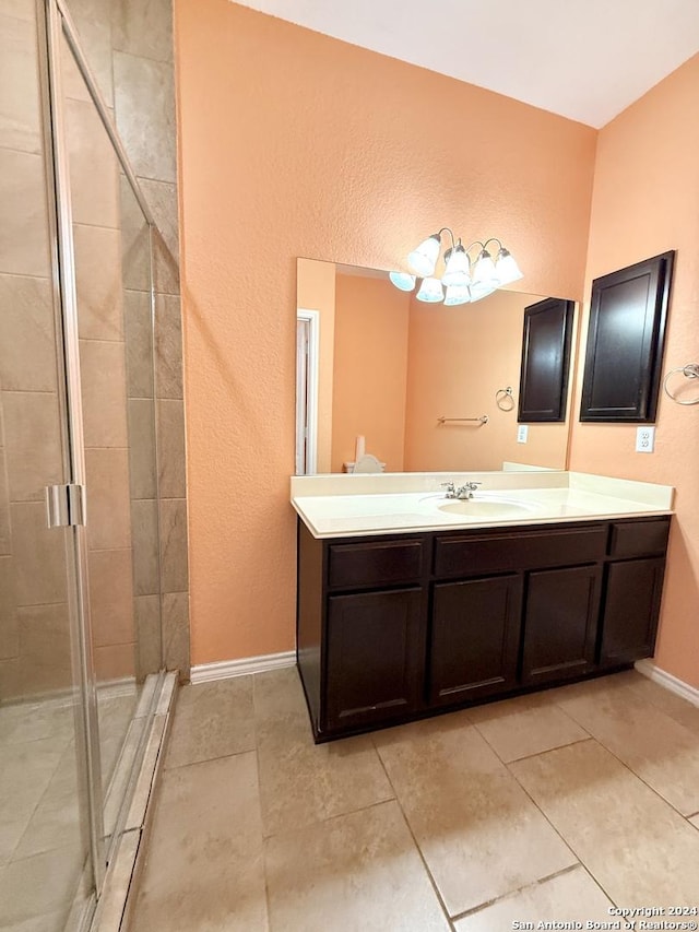 bathroom featuring tile patterned flooring, vanity, and a shower with shower door