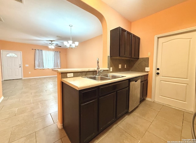 kitchen with sink, stainless steel dishwasher, backsplash, kitchen peninsula, and decorative light fixtures