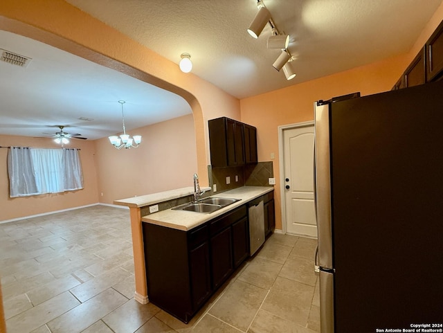 kitchen featuring dark brown cabinetry, sink, track lighting, ceiling fan with notable chandelier, and appliances with stainless steel finishes