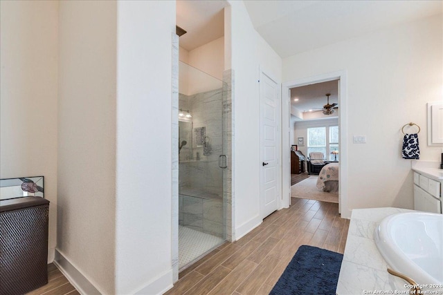 bathroom featuring hardwood / wood-style floors, separate shower and tub, and ceiling fan