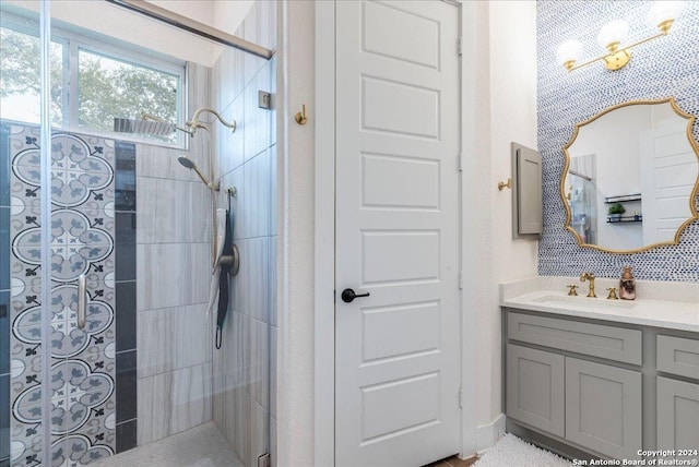 bathroom featuring tiled shower and vanity